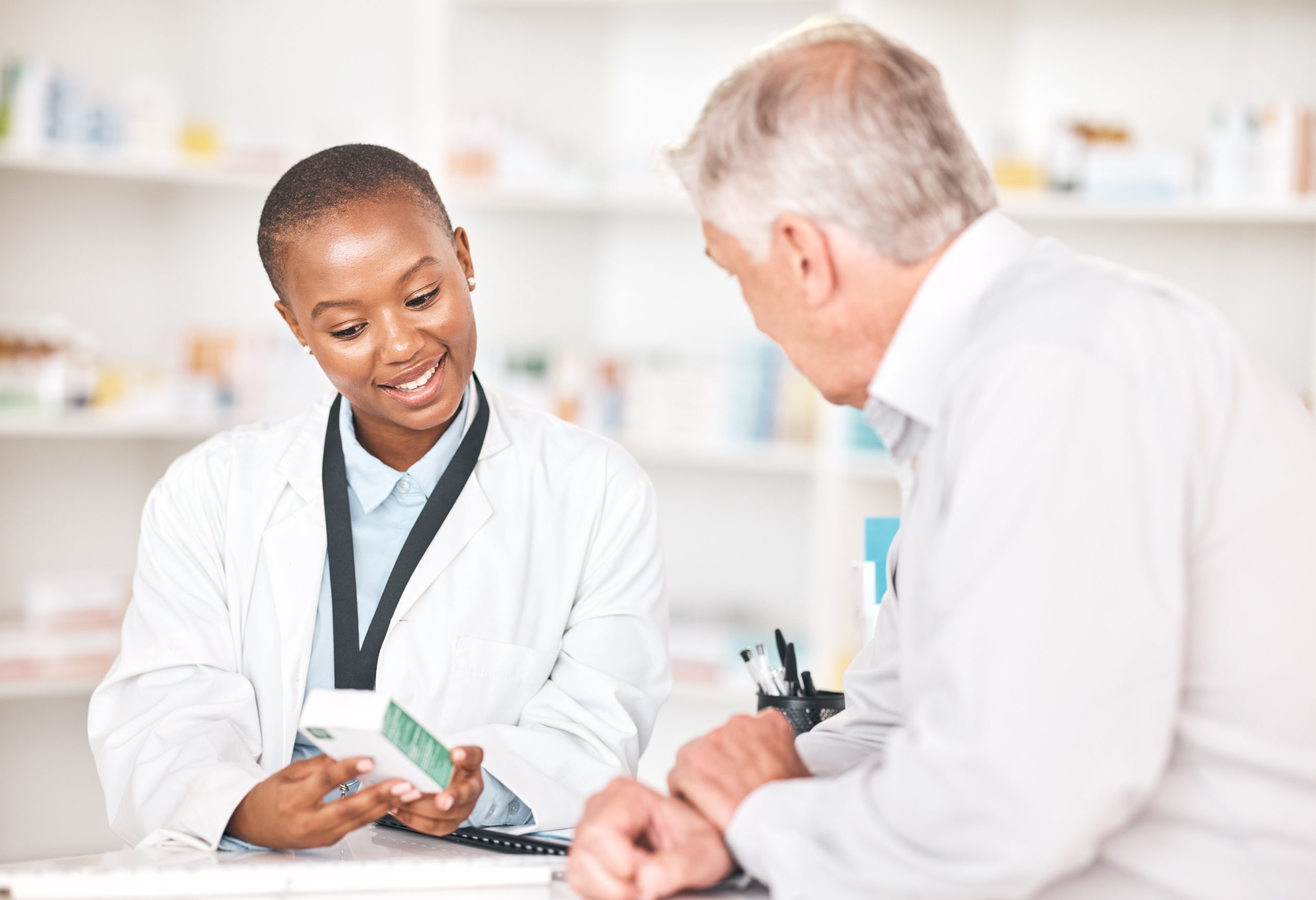 Pharmacist explaining Adipex medication to a patient at a counter