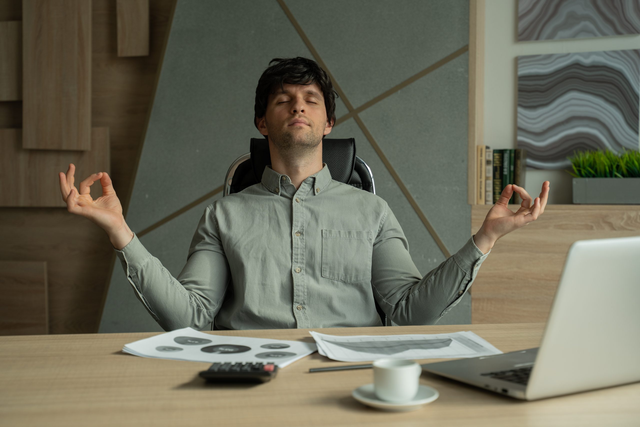 Man taking a mindful breathing break at his desk to manage work stress