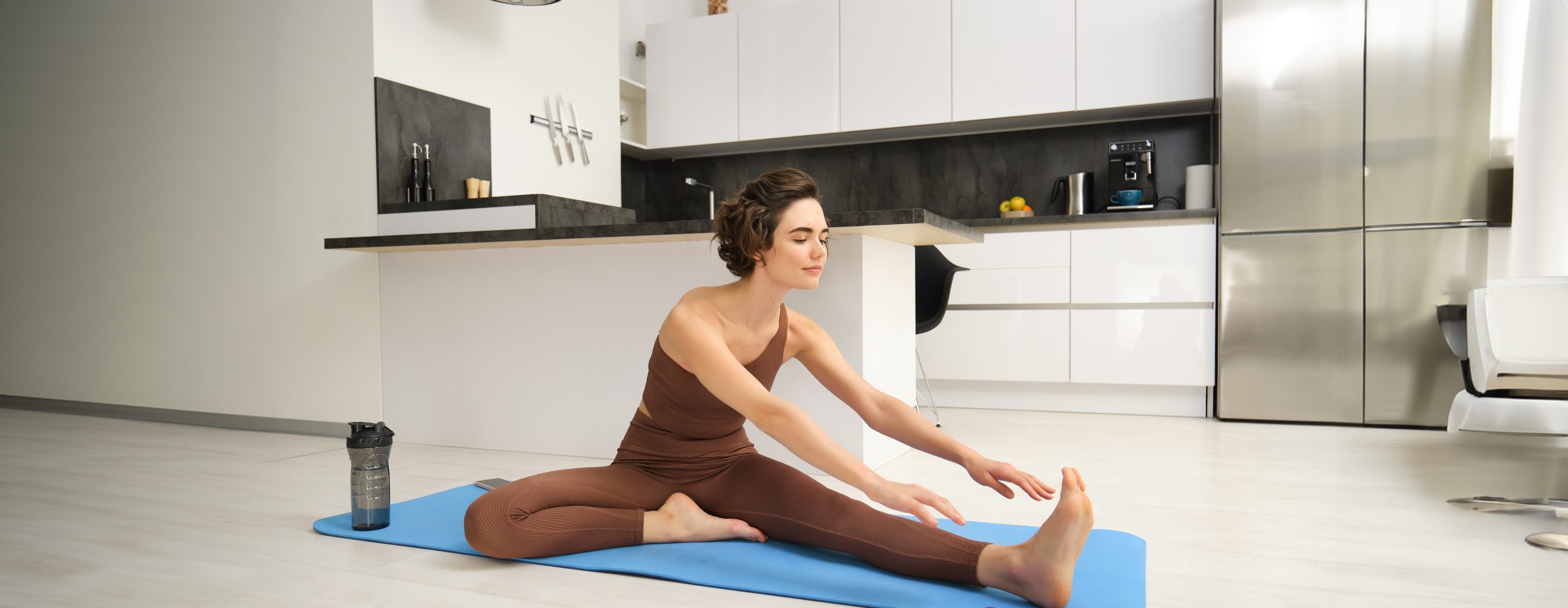 Woman stretching on a yoga mat during a light active recovery session at home