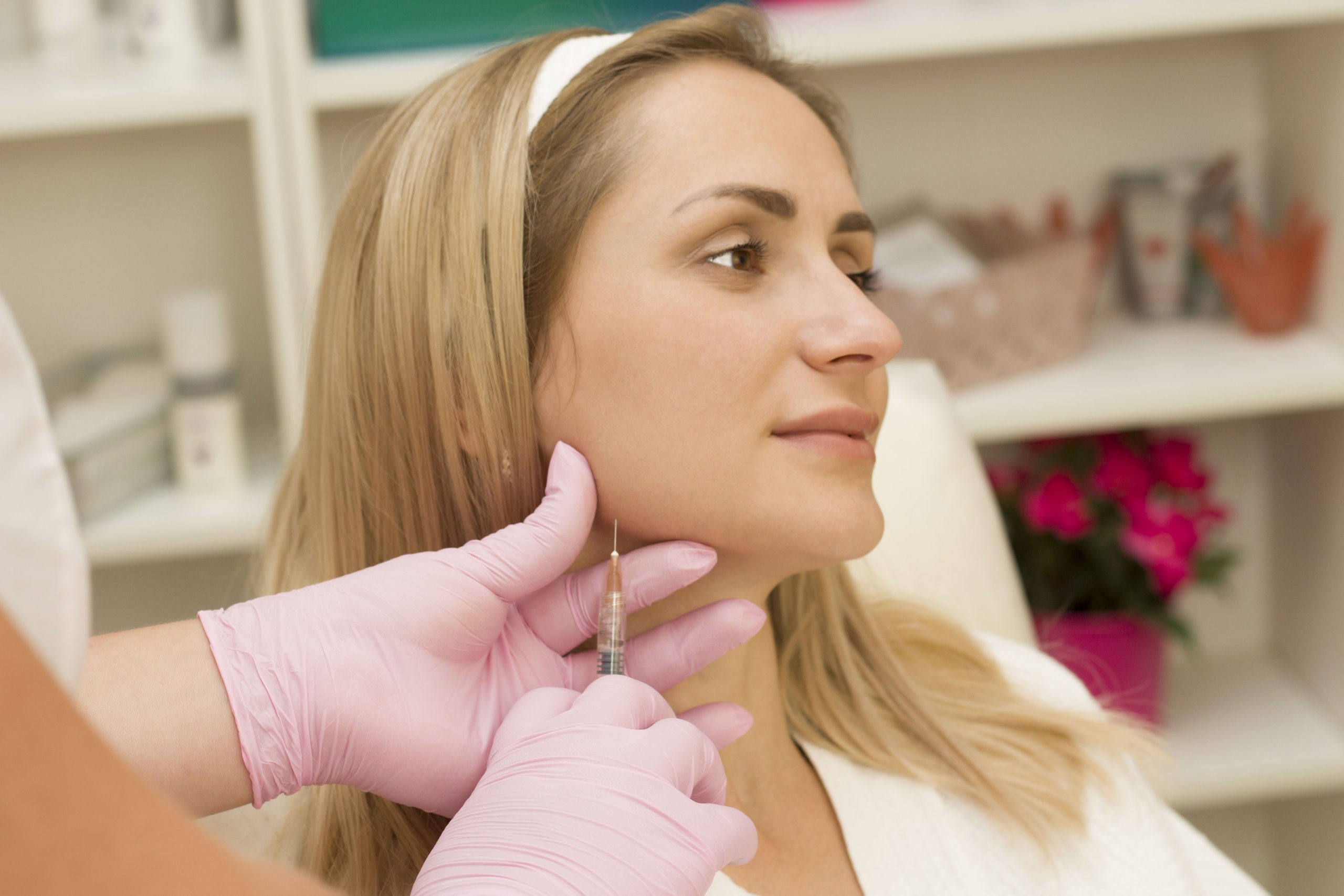 Provider giving a young woman an injectable anti-aging treatment in a clinic