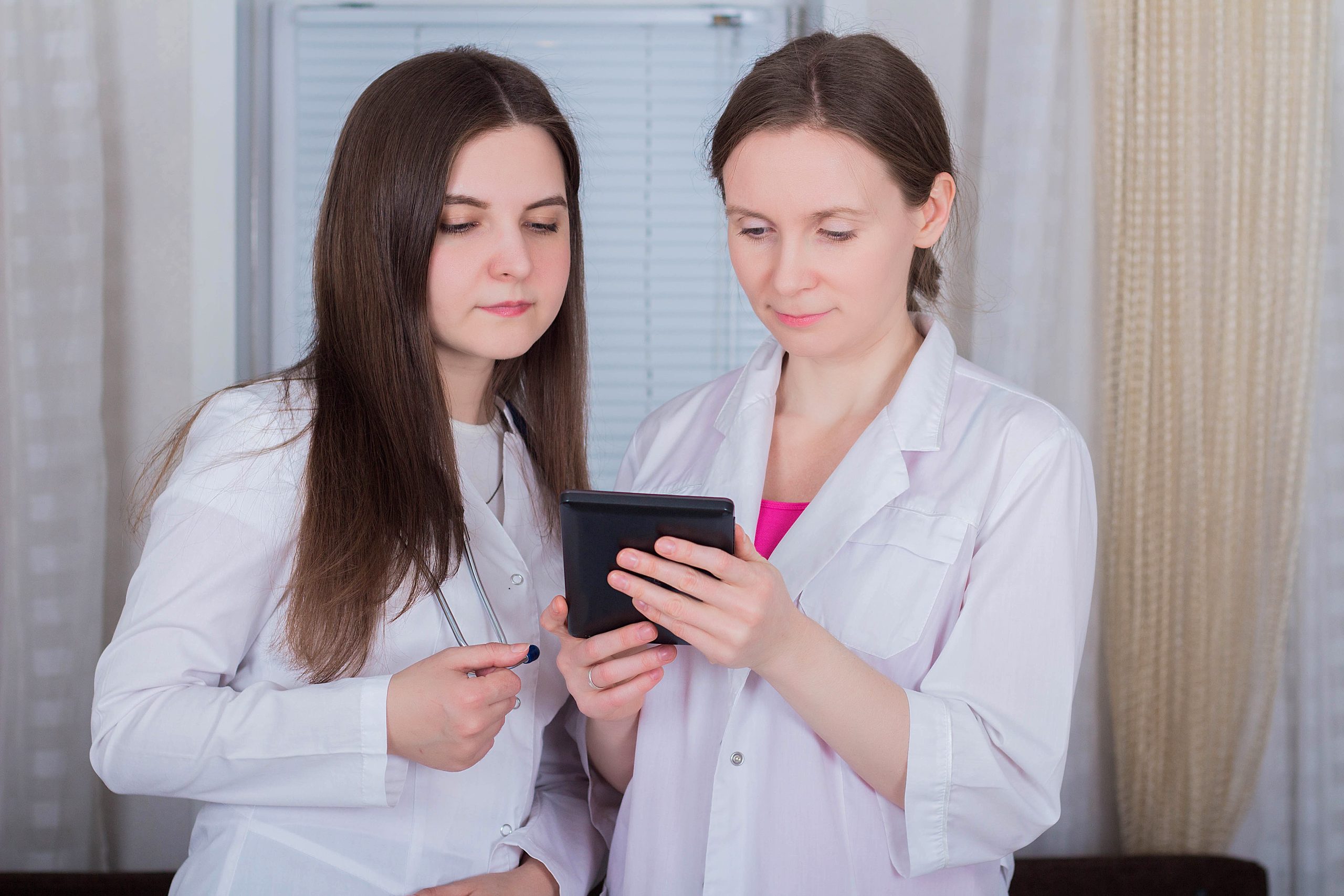 Two female doctors or nurses look at the tablet and discuss therapy What Are Anti Aging Treatments?